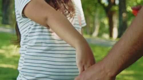 Father Spraying Mosquito Repellent on Daughter During Park Picnic