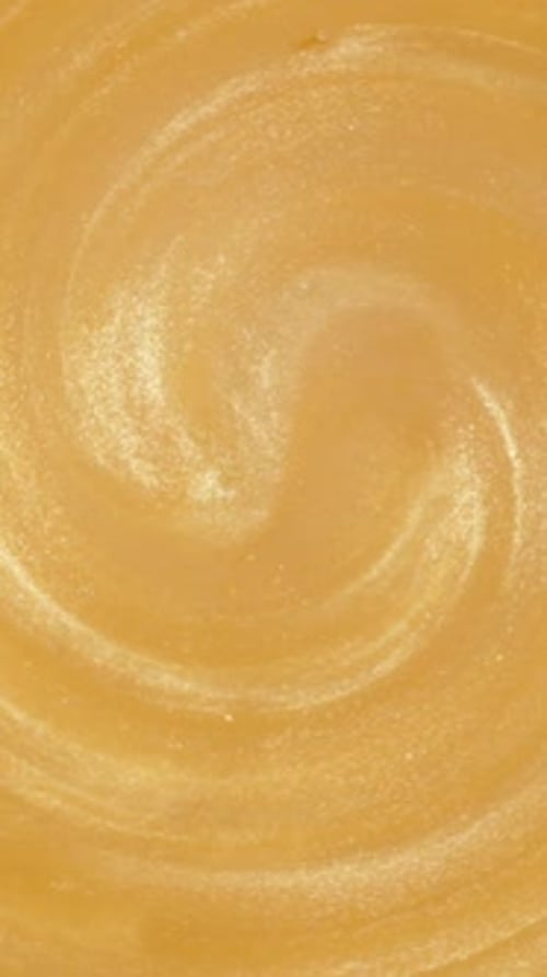 Vertical video. Golden Glitter Particles Spin in the Whirlpool. Macro.