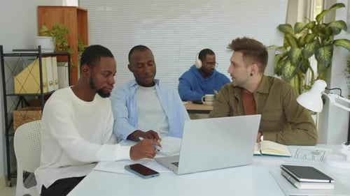 Diverse Startupers Looking at Business Plan on Laptop