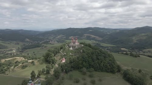 Small chapel on the top of the hill surrounded by mountains in Slovakia during cloudy day.