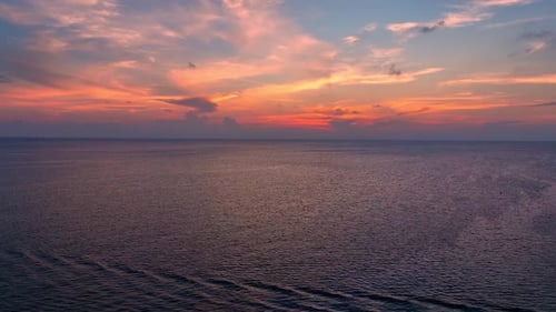 Drohnen-Luftaufnahme des endlosen Horizonts über dem Meer bei goldenem Sonnenuntergang. 4K.
