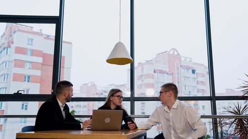 Team Meeting at Office Table with Laptop