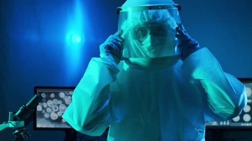Researcher in Hazmat Suit Puts on Face Shield