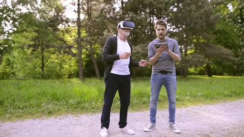 Senior man using VR with assistance in park