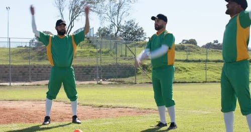 After signal Diverse male teammates in green uniforms raising and rotating arms warming up on field