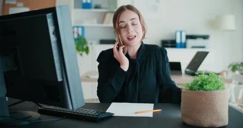 Woman Talking on Phone in Bright Office