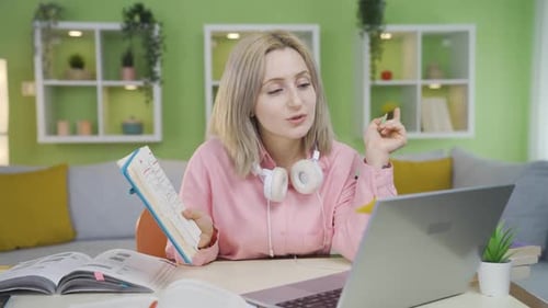 University student girl studying with her friend by video call.
