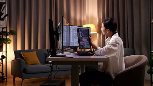 Femme programmeuse regardant une base de données sur une tablette tout en créant une Appli d'ingénieur logiciel