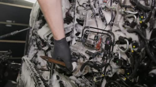 Mechanic Cleaning a Car Engine with Brush