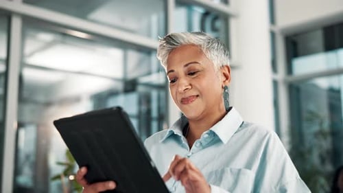 Office, smile and mature woman with tablet for digital network, research and reading finance news