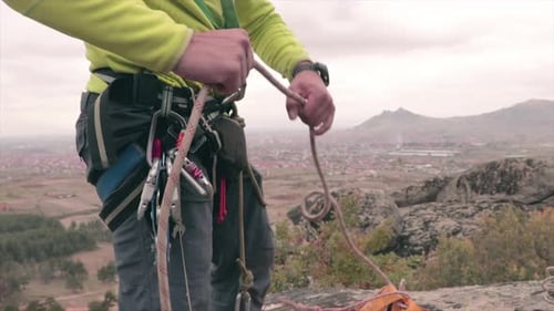 Alpinista com um equipamento de escalada tirando uma corda de uma bolsa. Esporte radical.