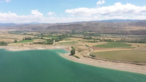 Vue aérienne de la rive asséchée du lac, des collines et des terres agricoles