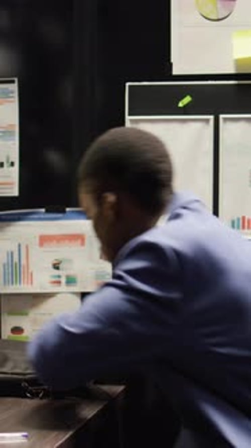 Young Adult Putting Papers Into Briefcase at Night