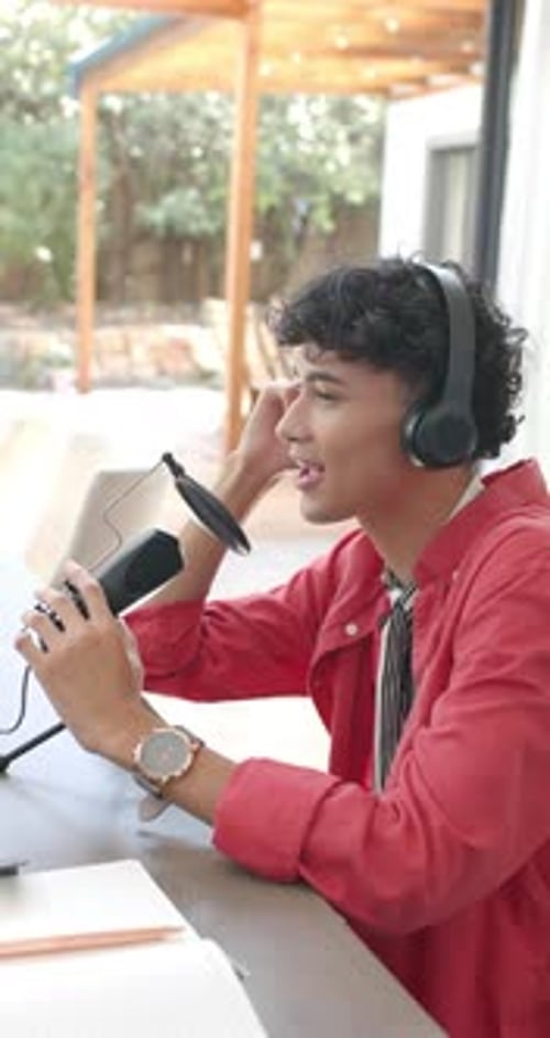 Young Adult Recording Podcast With Microphone Indoors