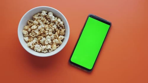 Top View of Smart Phone and Popcorn on Table
