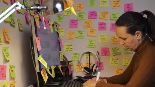 Female Worker Adding Sticky Notes to a Wall