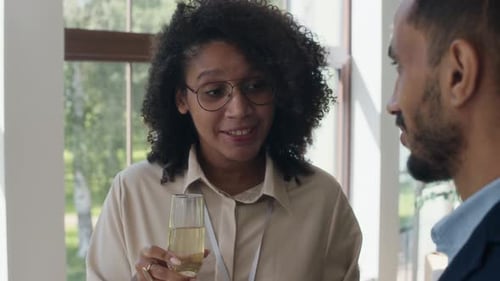 Black Woman Chatting with Colleague during Small Party after Presentation
