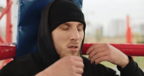Man with Beard Resting in Boxing Ring Corner