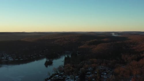 Quick drone flyover lake houses in a rural mountain area at winter sunrise. in 4K.