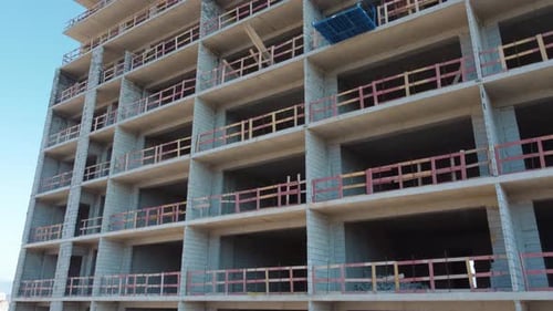Nuevo complejo de apartamentos altos sin terminar contra el cielo azul,
