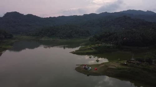 Luftbild von Menschen, die in der Nähe des Sees campen, mit einer wunderschönen Sonnenuntergangsatmosphäre
