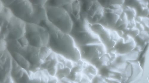 Close Up Shot of Cream Background Face or Body Cream Fluid Texture with Peaks Rotating Smooth