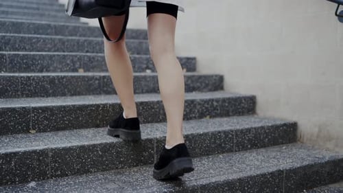 Cropped view on woman go to work and walk upstairs