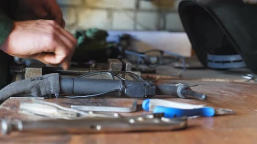 Male Hand of Repairer Putting Protective Glasses on the Table in Garage