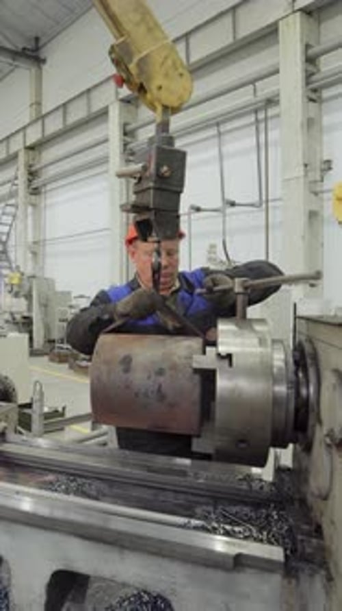 Factory Worker Operating Lathe Machine in Manufacturing Plant Stock Clip