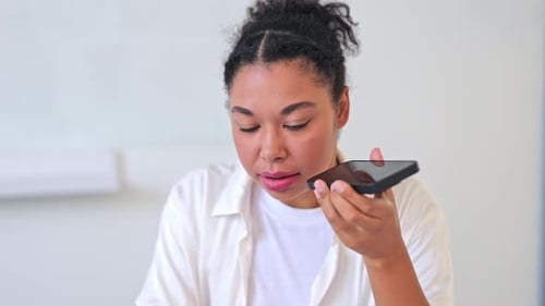 Woman Using Voice Assistant on Smartphone Indoors