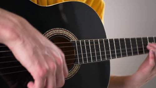 Guitarist Playing Black Acoustic Guitar in Close Up
