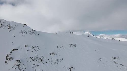 Vue prise par un drone Flyover Slowmotion, survolant deux skieurs, révélant le sommet de la Vihren en
