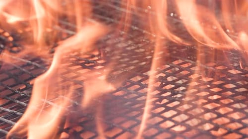 Detailansicht der offenen Orangenflammen unter dem BBQ-Grill