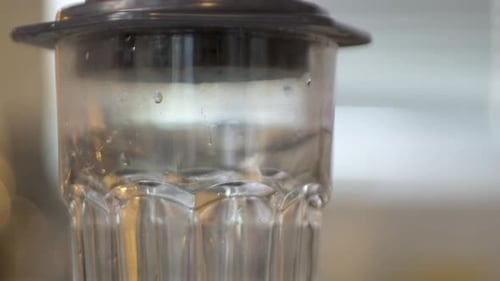 Clear Glass Being Filled with Brown Liquid