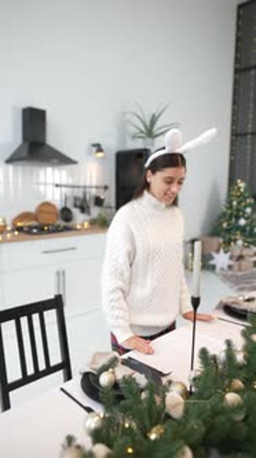 Young Woman Setting New Year's Table at Living Room