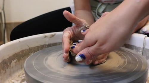 Potter Shaping Clay on a Spinning Pottery Wheel