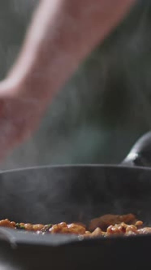 Close-up of Unrecognizable Man Pouring Alcohol into Skillet Before Igniting It