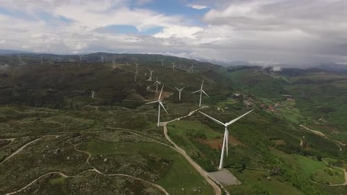 Wind Turbines Powering Rural Green Hills by Aerial View