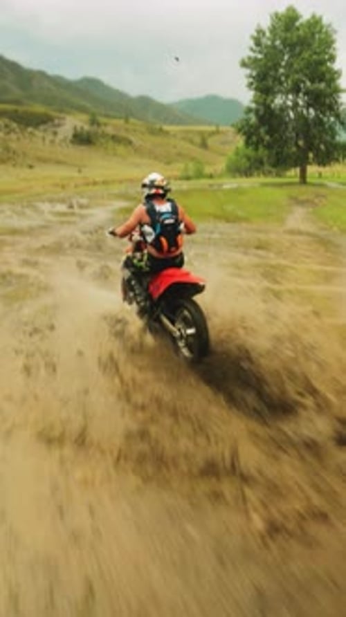 Dirt Bike Rider Splashing Through Muddy Terrain