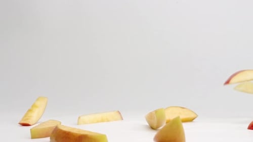 Sliced Apples Falling on a White Background