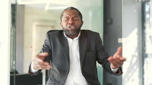 Webcam view. Angry african american businessman in formal suit arguing gesturing looking at camera w