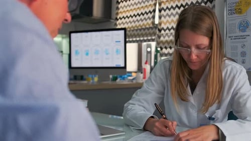 Doctor Giving Prescription to Patient in Medical Office