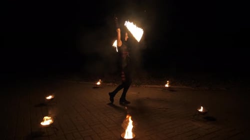 Woman Juggling Flames at Night Time Fire Dancer