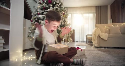 Excited Boy Opening a Magical Christmas Gift