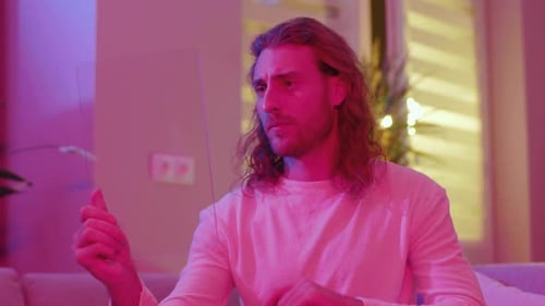 Man Interacts with Futuristic Transparent Tablet in Living Room
