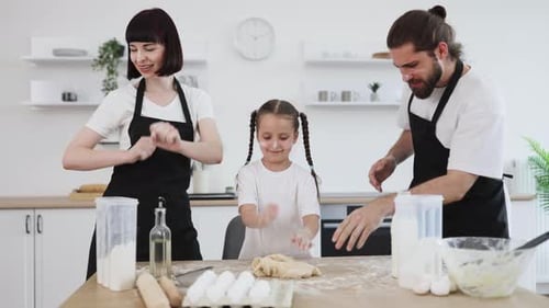 Happy Family Making Dough Together in Kitchen