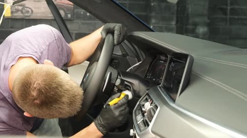 Man Detailing Car Interior with Soft Brush
