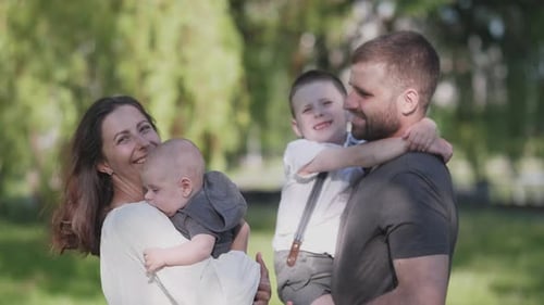 Happy Family Portrait in the Park on Sunny Day