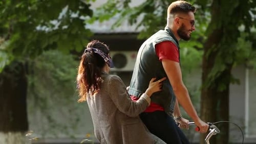 Jovem casal andando de bicicleta juntos no parque Namorado romântico andando de bicicleta com namorada feliz