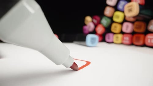 Mehrfarbige Markierungen auf dem Tisch. Eine rote Markierung zeichnet eine gekrümmte Linie auf das Papier. Dolly Slider extra